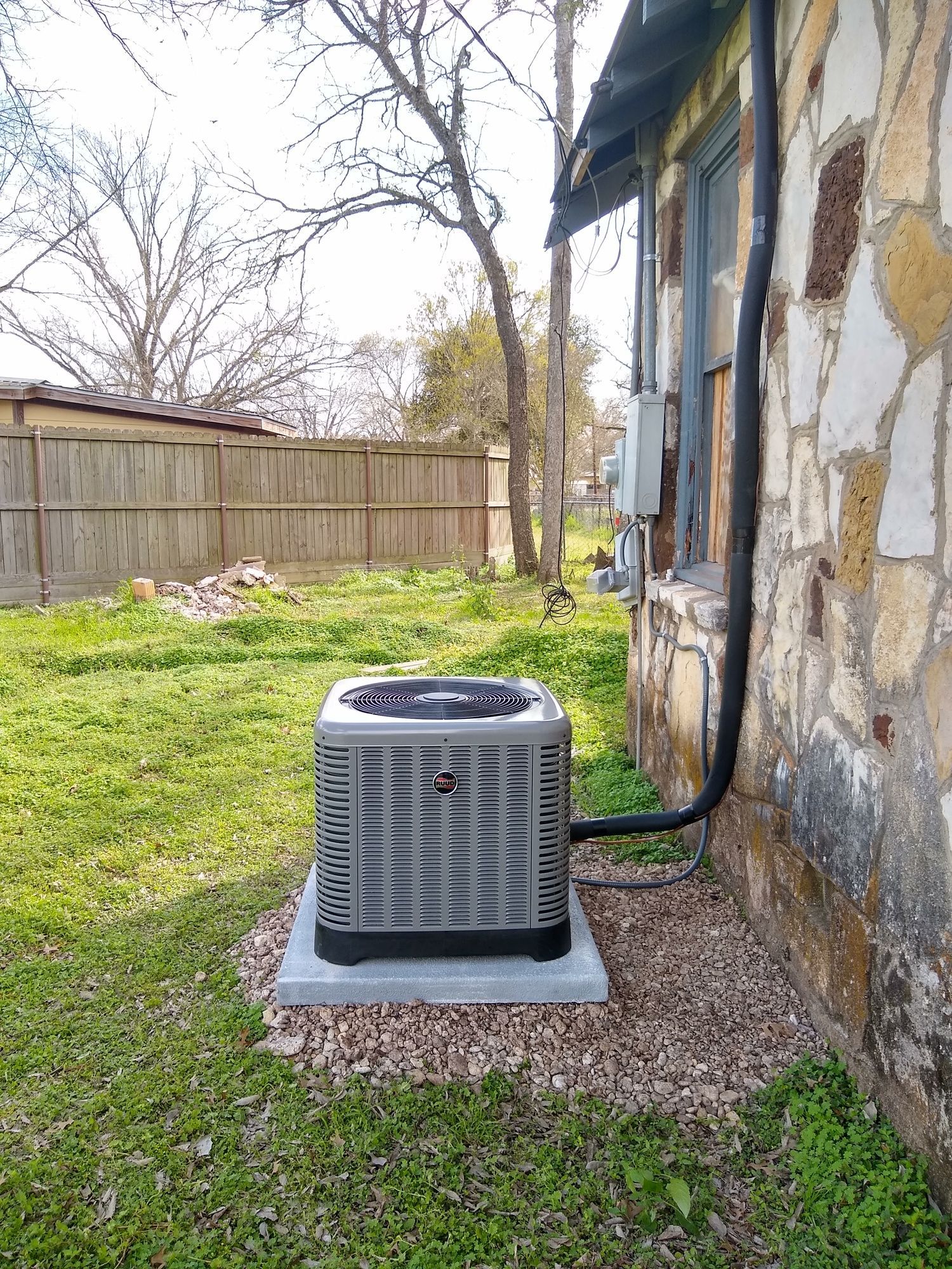An air conditioner is sitting on the side of a house.