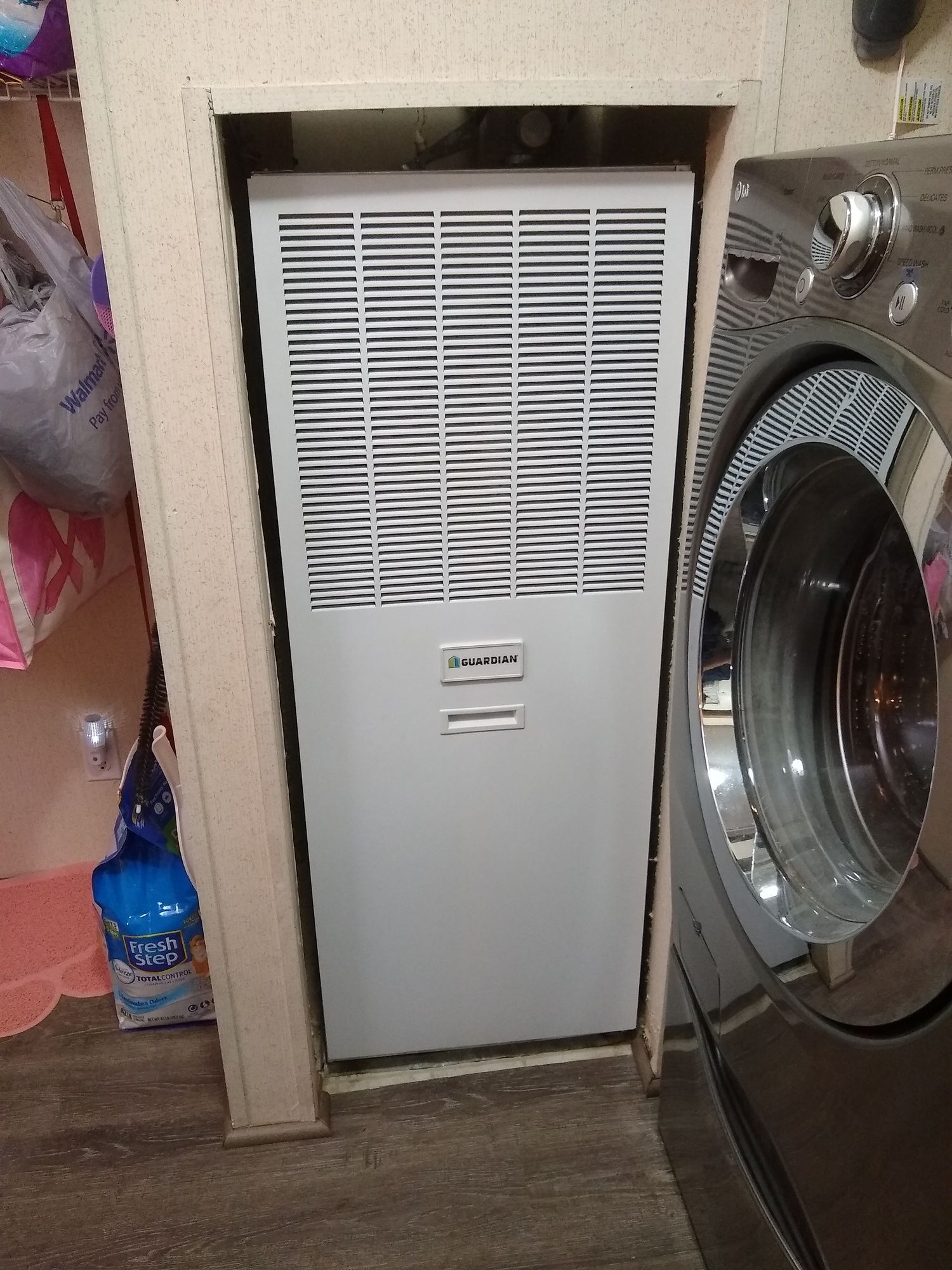 A washer and dryer are in a laundry room next to a heater.