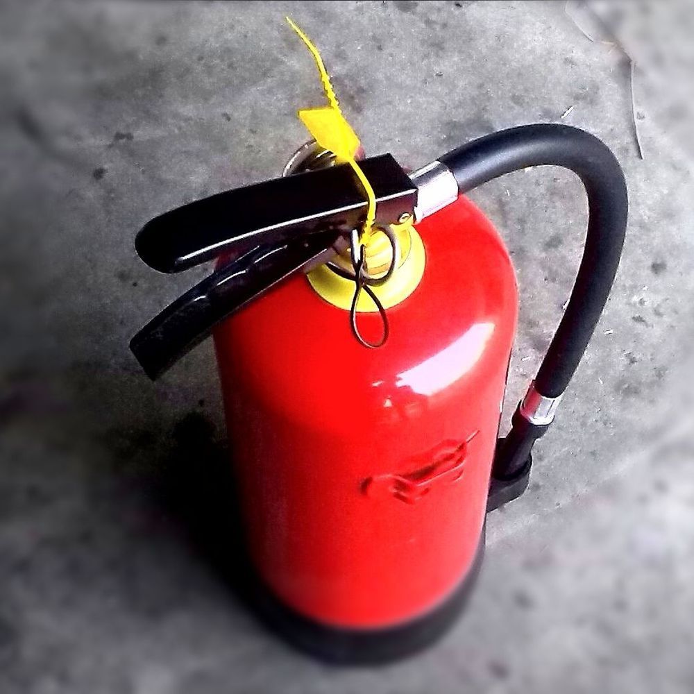 A red fire extinguisher with a yellow tag on it