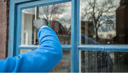 A person is cleaning a window with a squeegee