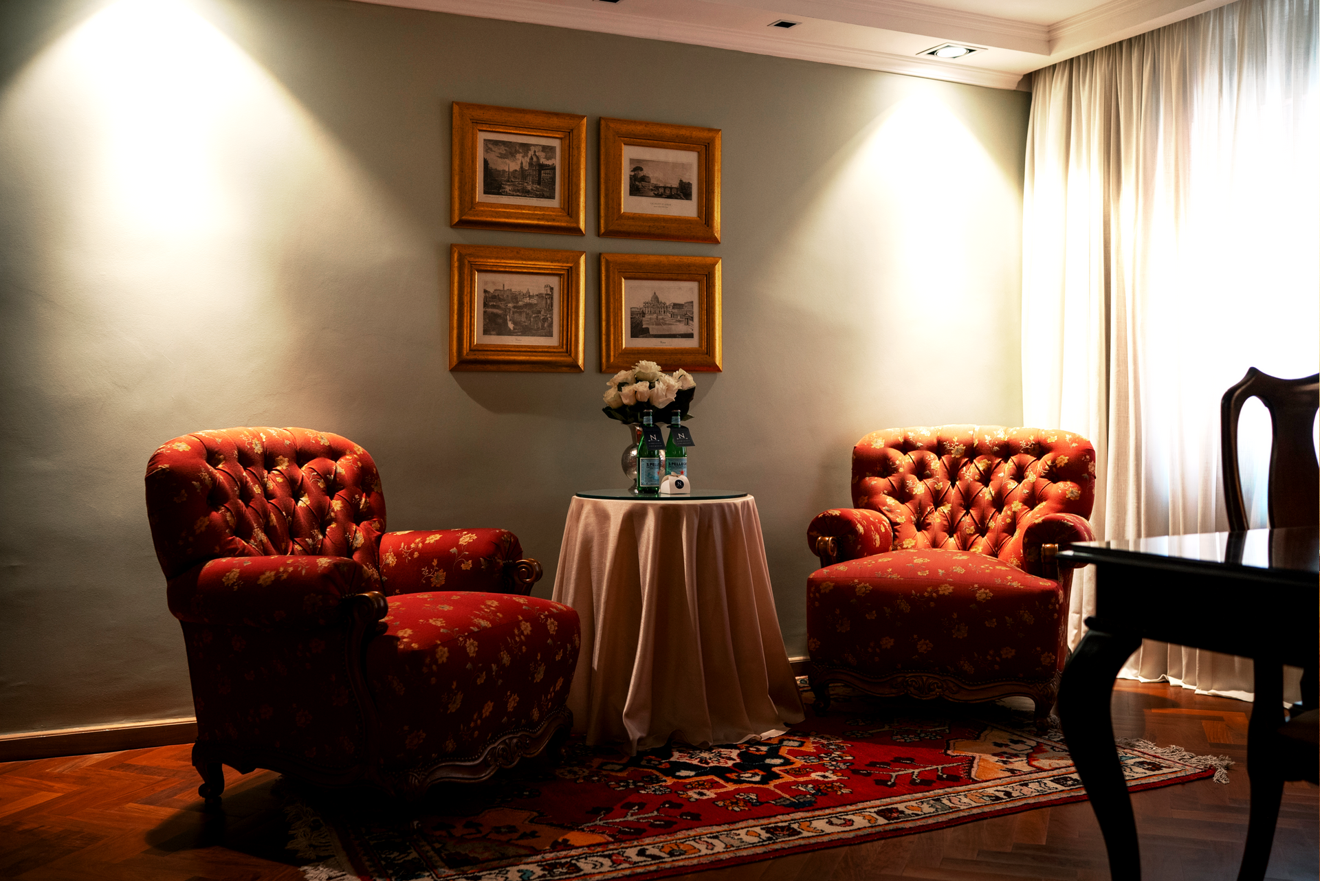 Una habitación de hotel con una cama de matrimonio, muebles de madera, una alfombra estampada y un televisor de pantalla plana sobre un mueble de madera oscura.