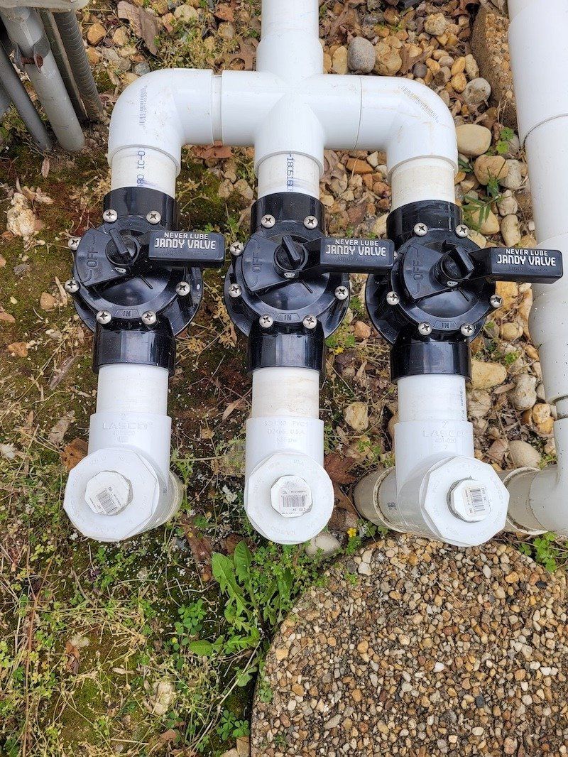 A close up of a hose with three valves attached to it.