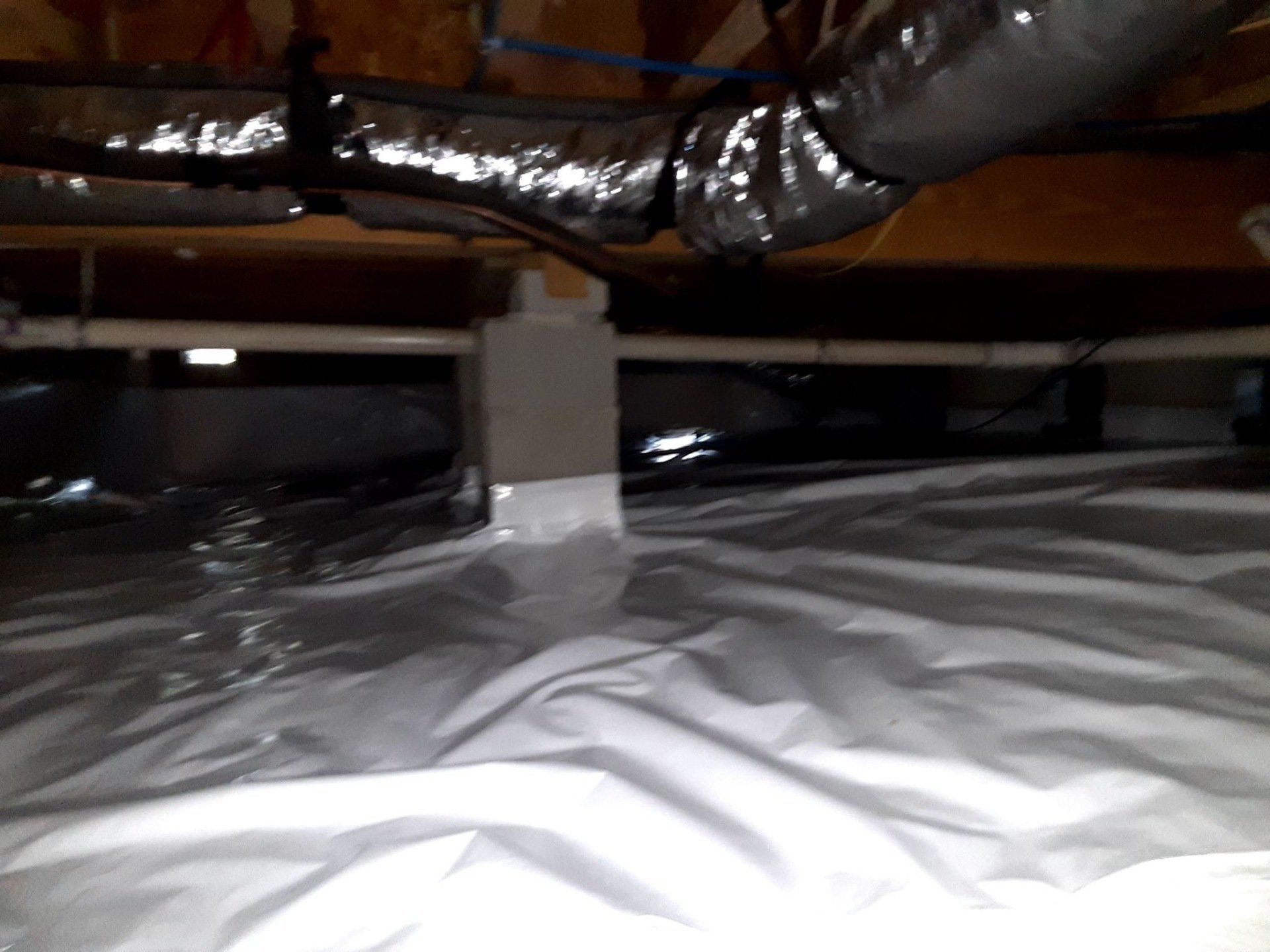 A white sheet is laying on the floor in a basement