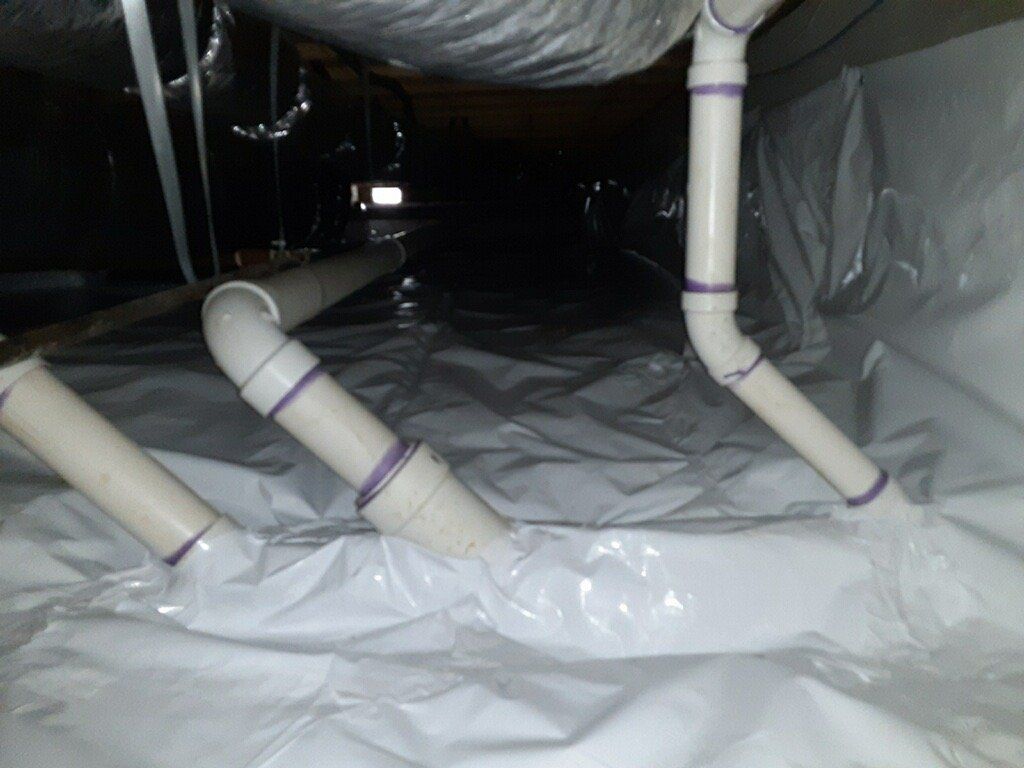 Crawlspace under a residential building with new vapor barrier.
