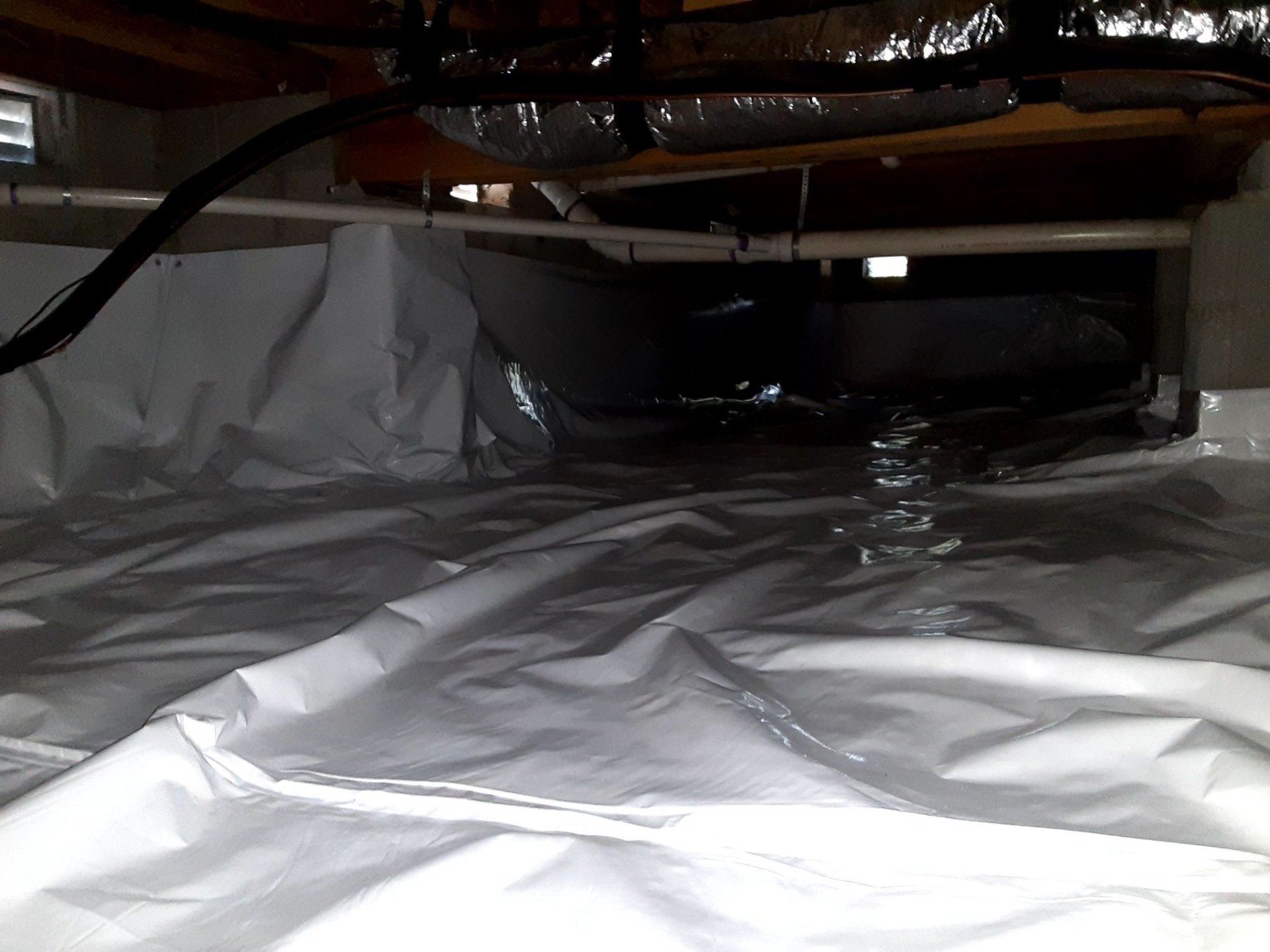 A basement filled with plastic and pipes.