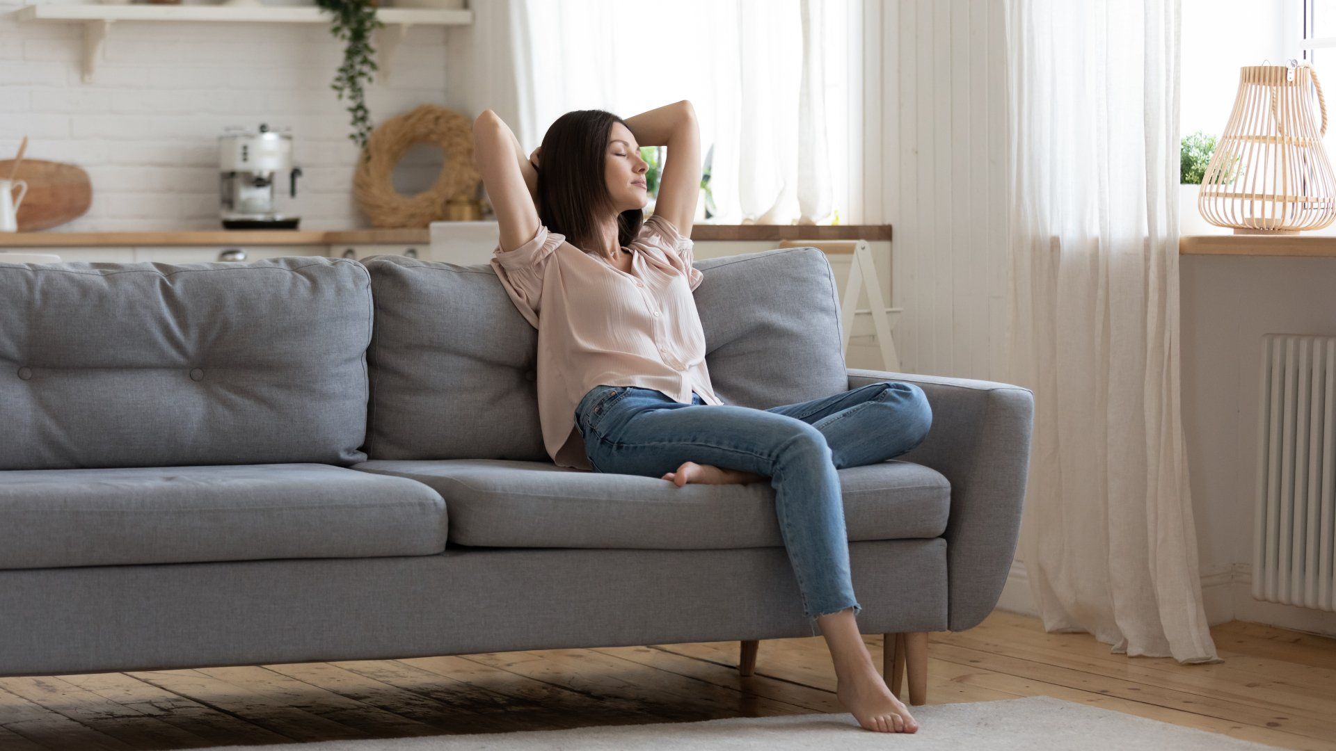 Serene lady housewife lounge sit on sofa feel fatigue napping hold hands behind head