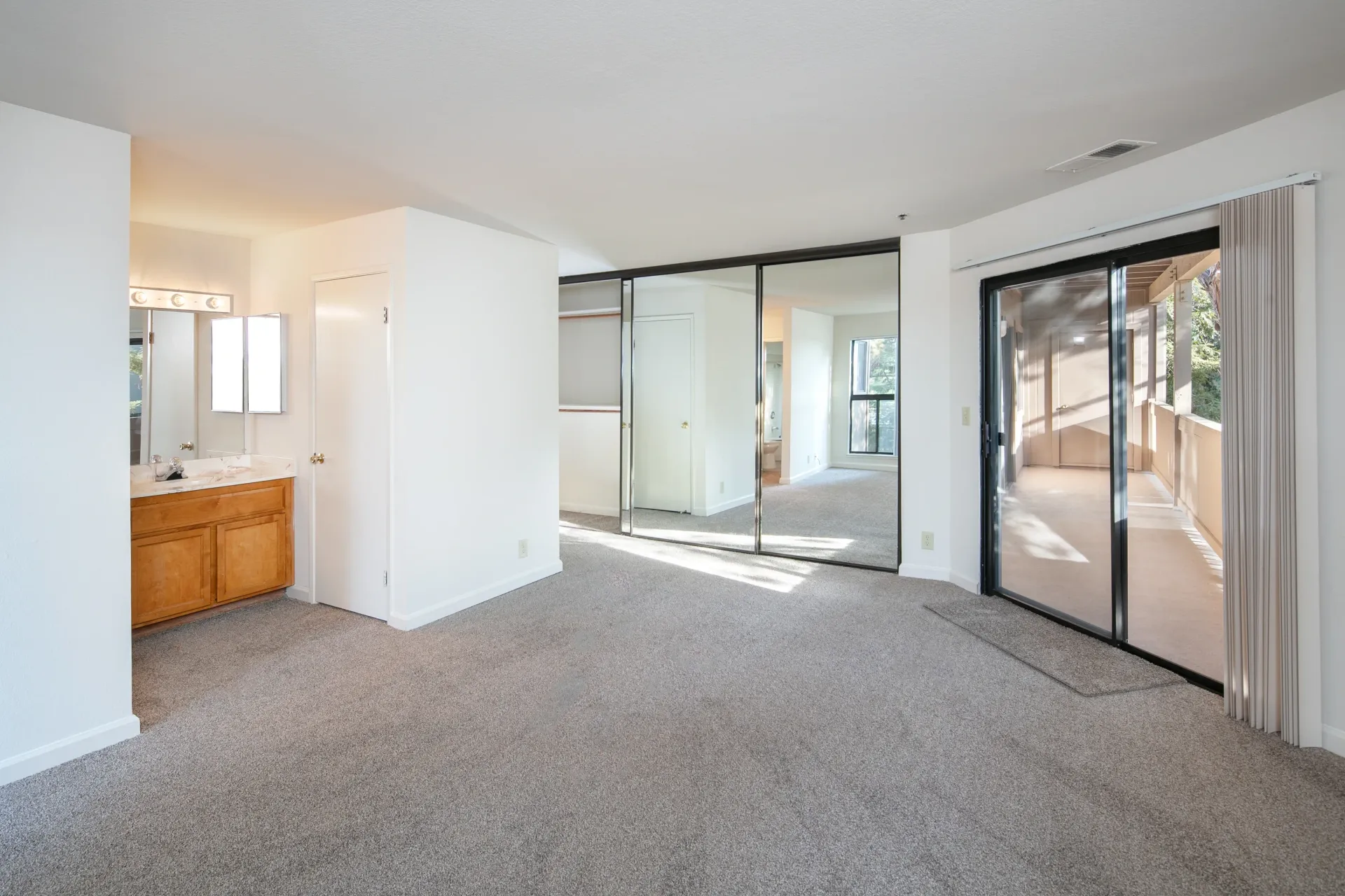Spacious bedroom with vanity and closet space with mirrored doors.