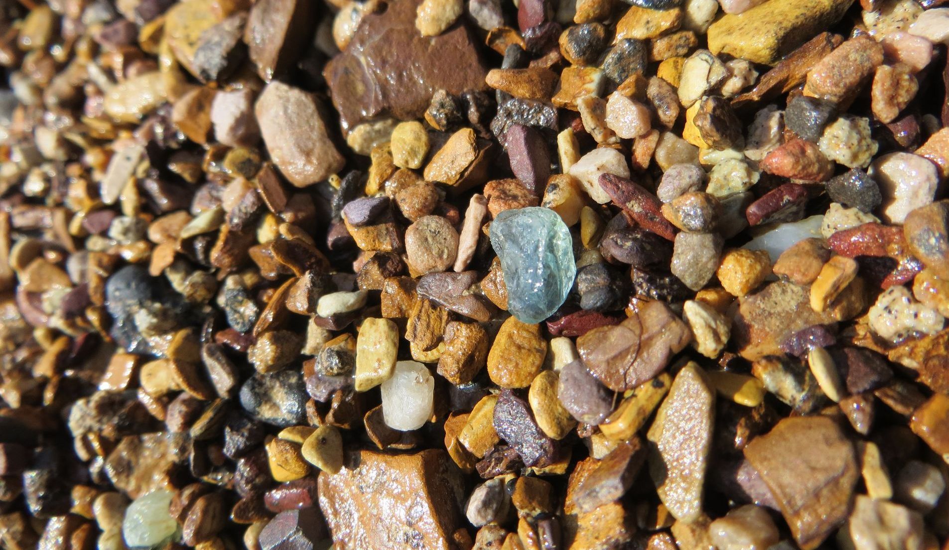 A pile of rocks with a blue stone in the middle.