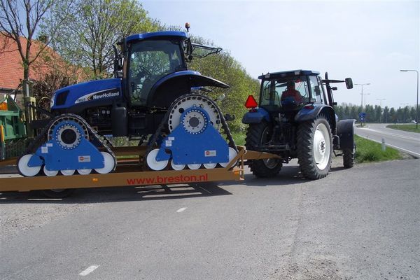 Two tractors are parked on the side of the road