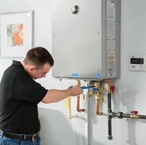 Fast Track Plumbing technician performing Plumbing Installation Spring TX on a wall-mounted boiler with pipes and gauges.