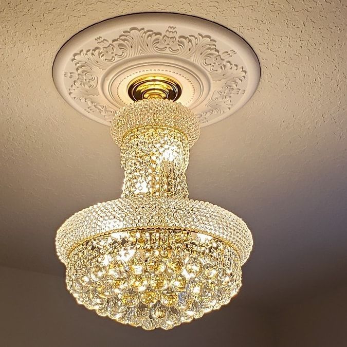 Crystal chandelier hanging from a decorative ceiling medallion.