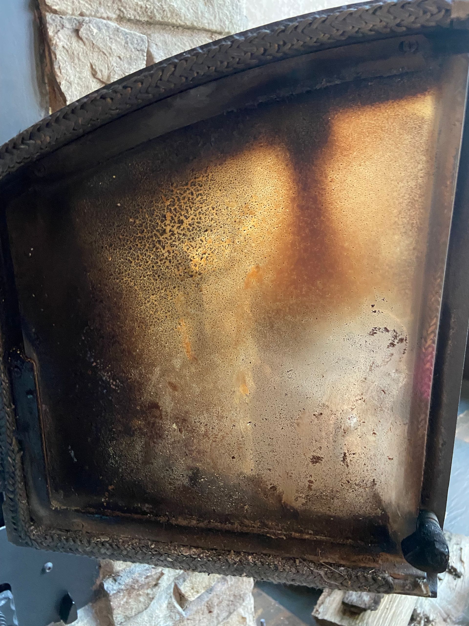 A close up of a dirty glass door on a fireplace.