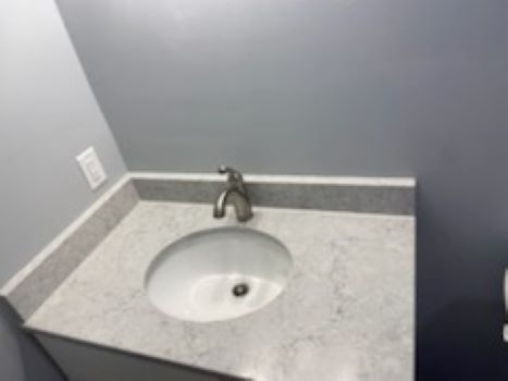 A bathroom sink with a faucet on top of it.
