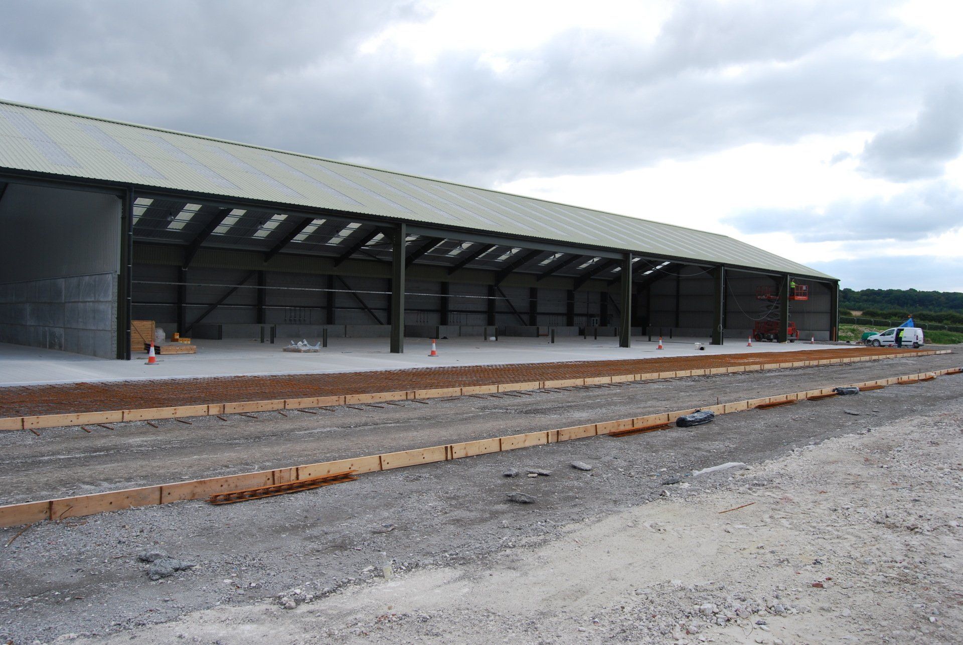 A large building is being built on a dirt road