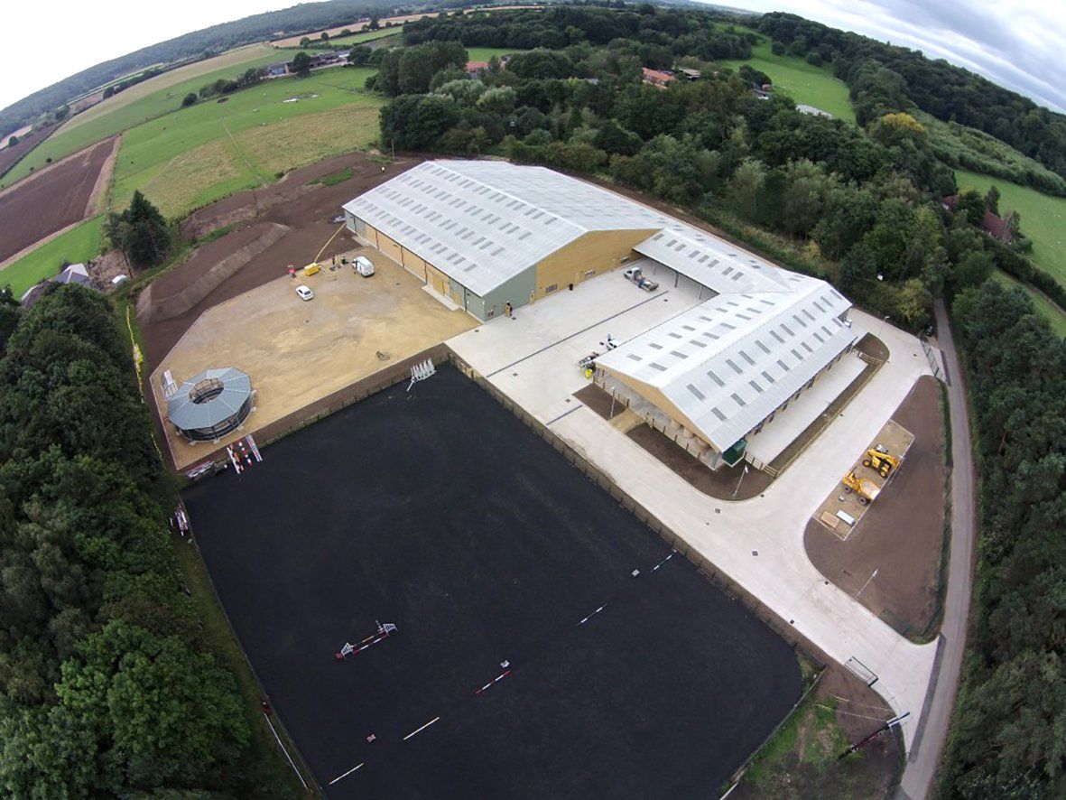 An aerial view of a large building in the middle of a field