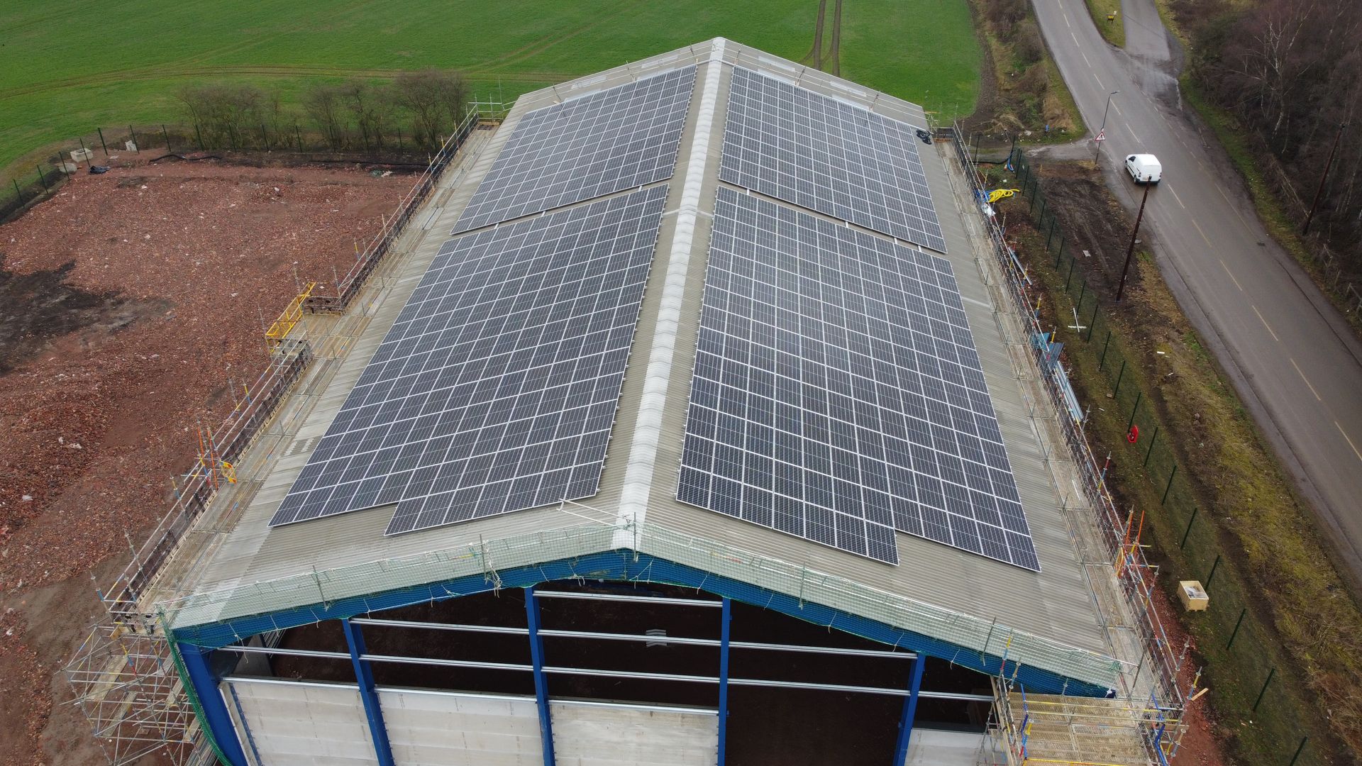 An aerial view of a building with solar panels on the roof.