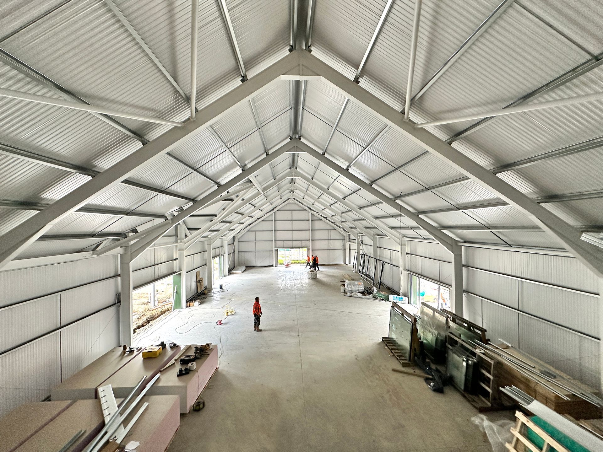 A man is standing in the middle of a large warehouse.