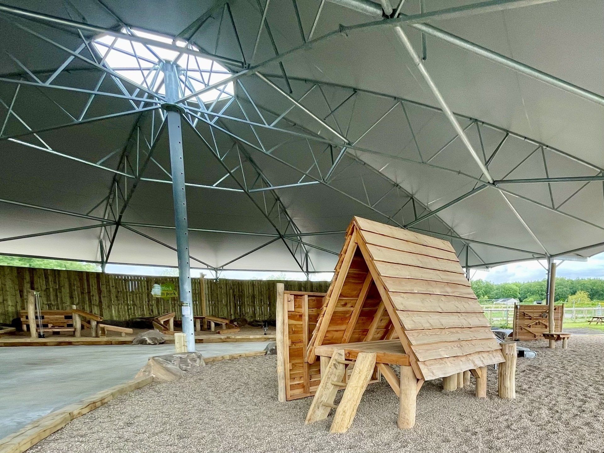 A wooden playhouse is under a roundhouse