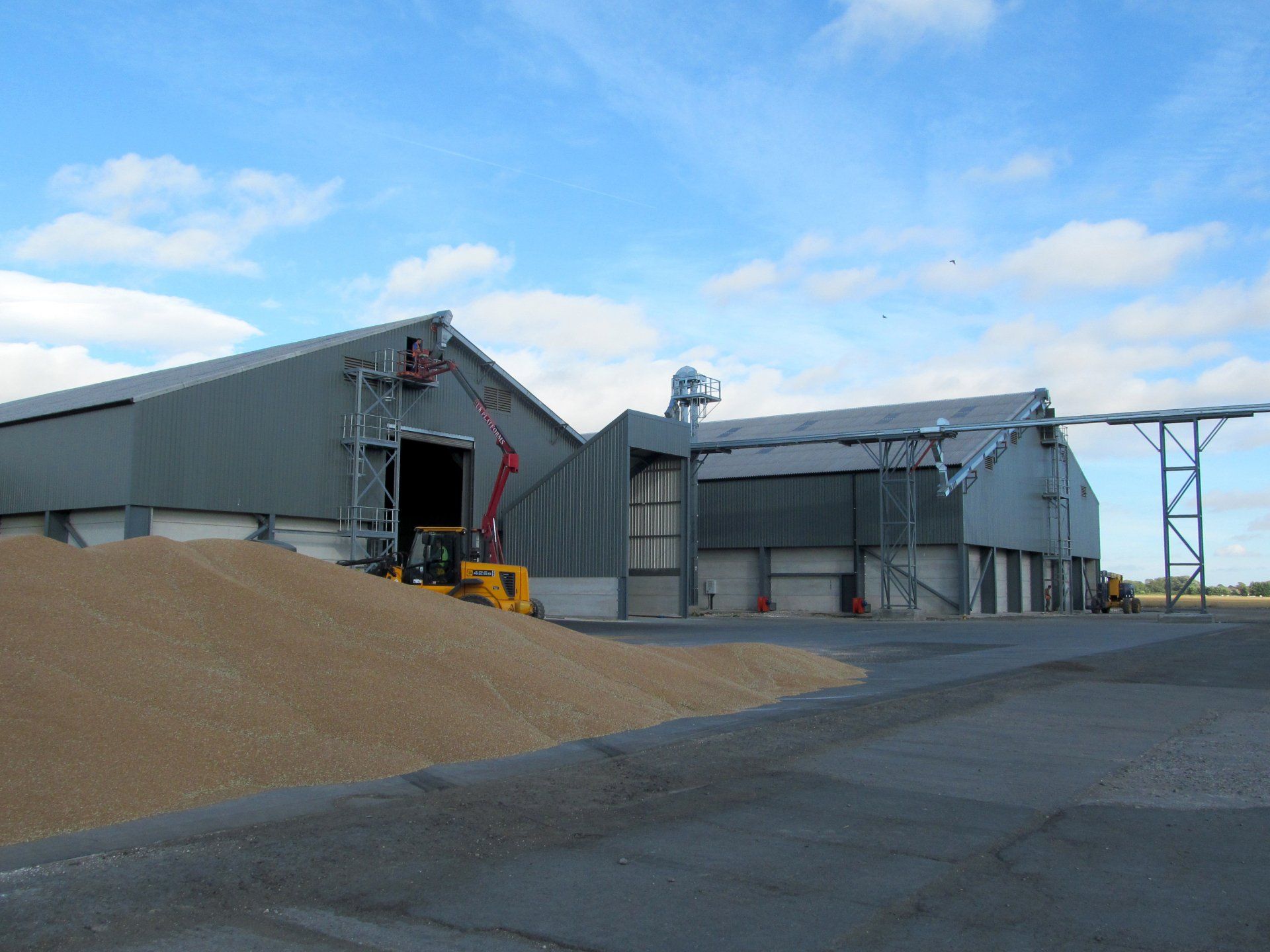 A large building with a lot of grain in front of it.