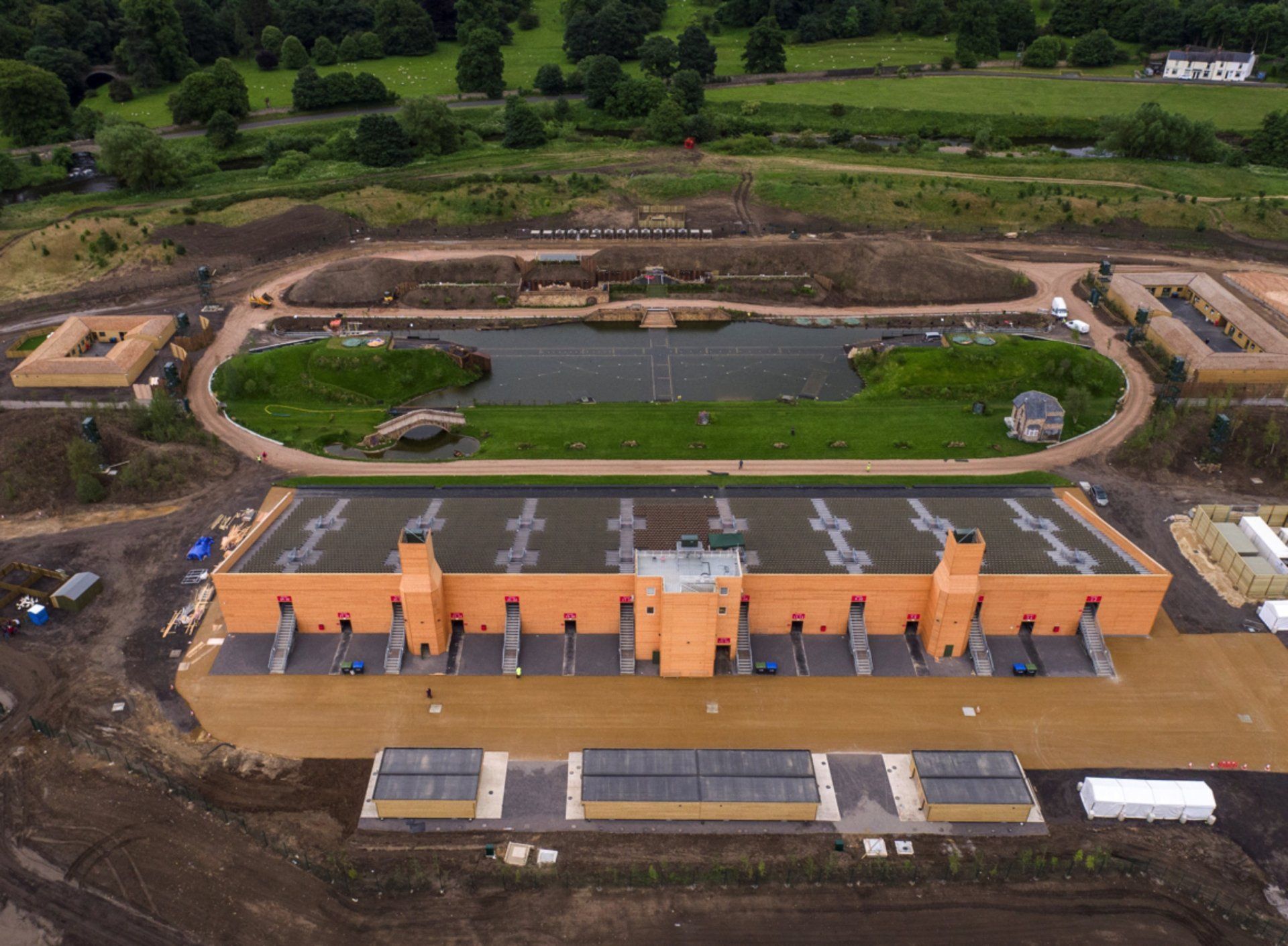 An aerial view of a large building with a pond in the middle of it.