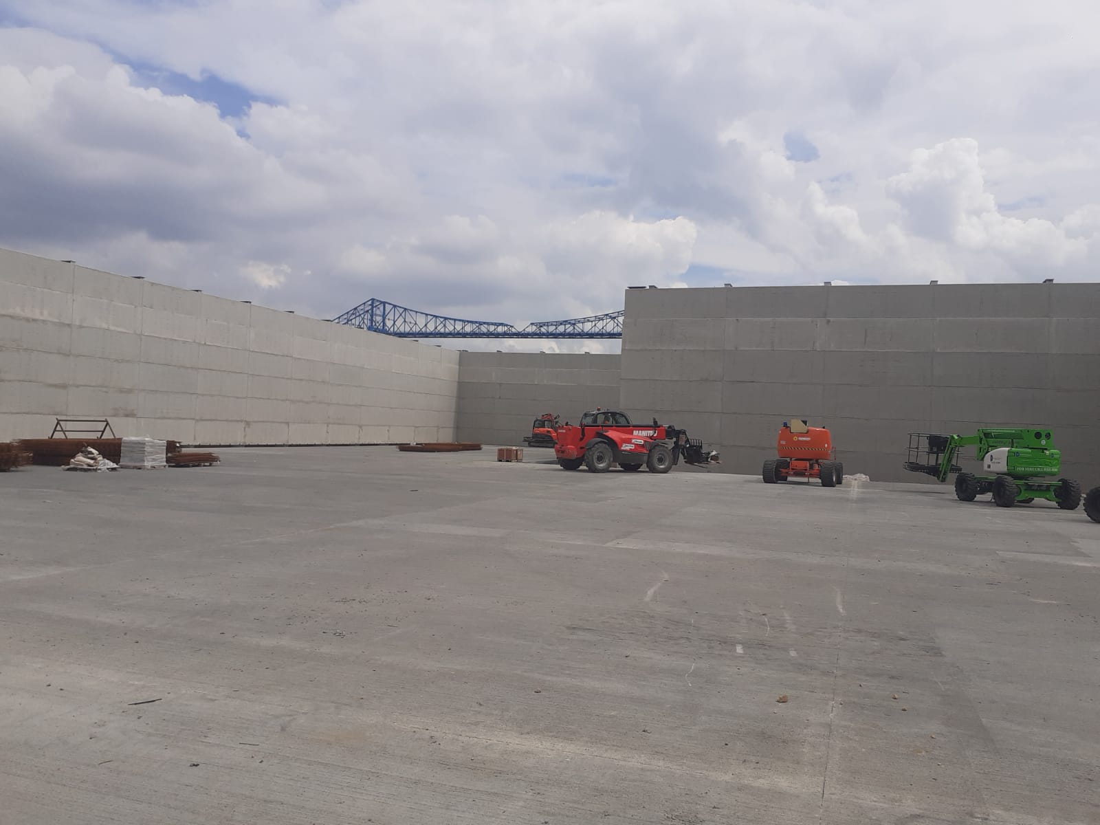 A lot of trucks are parked in a parking lot in front of a building.