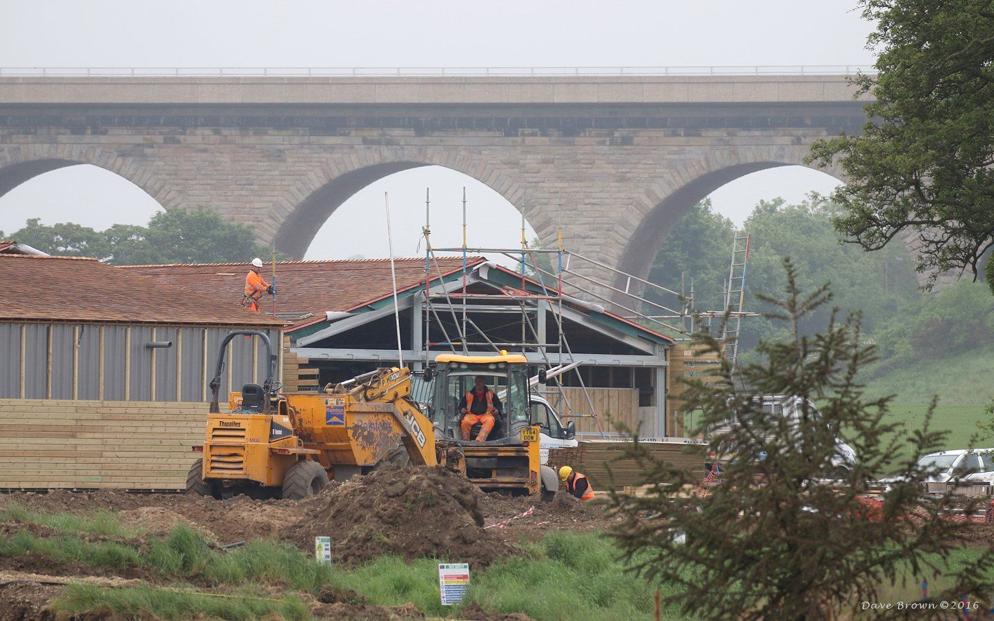 A construction site with a bridge in the background.