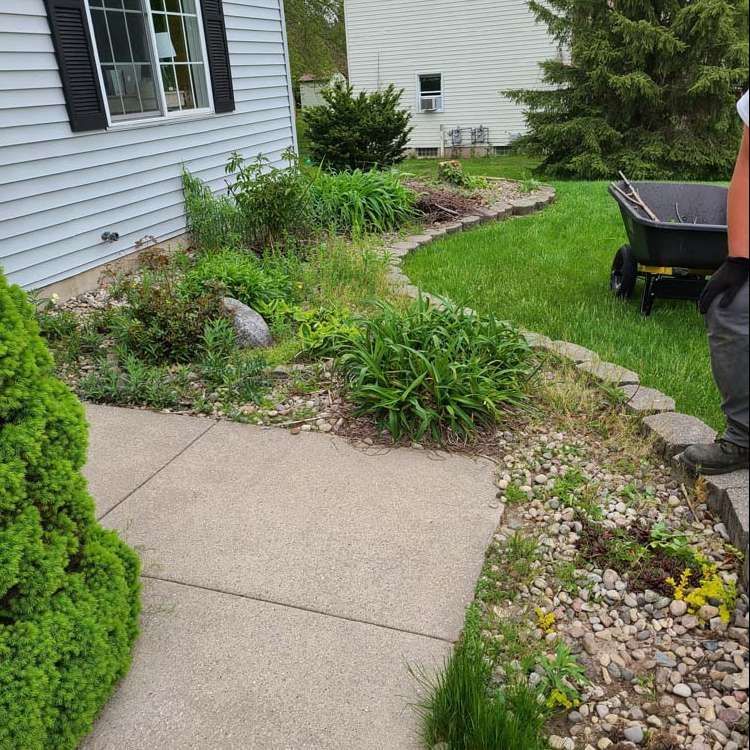 A Man is Standing Next to a Wheelbarrow in Front of a House