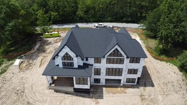 An aerial view of a house under construction with a black roof.