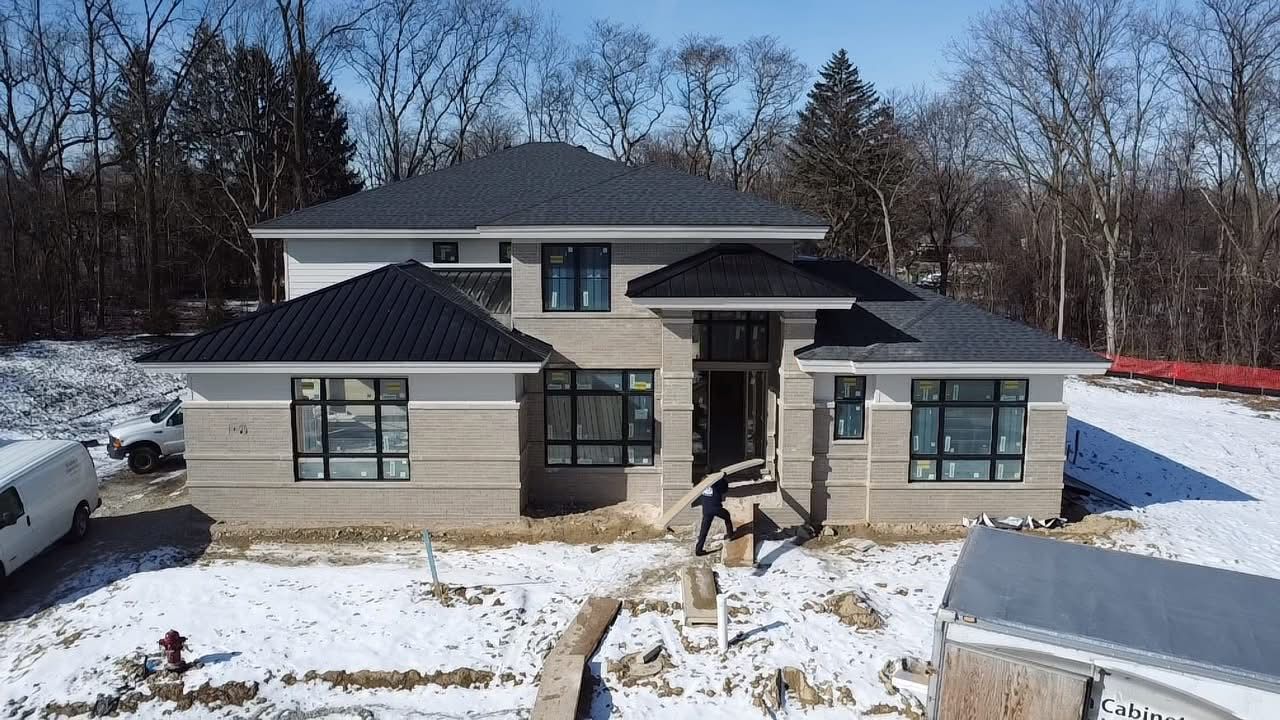 An aerial view of a house under construction in the snow.