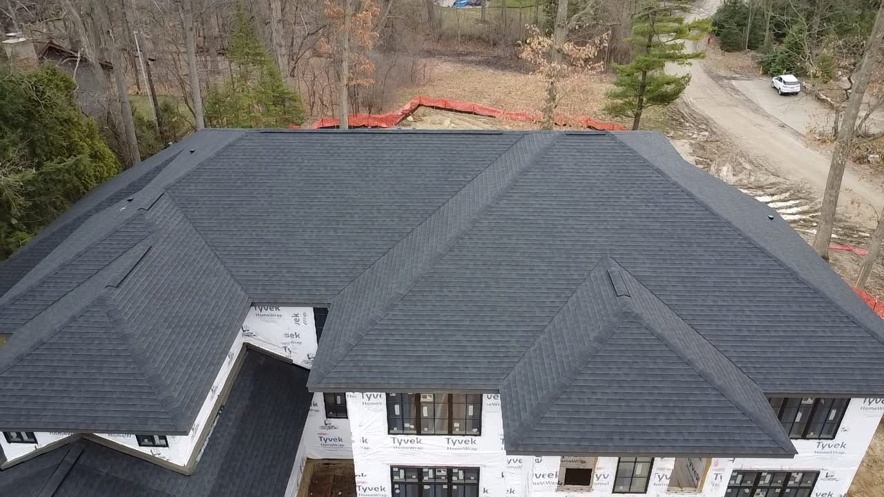 An aerial view of a house under construction with a black roof.