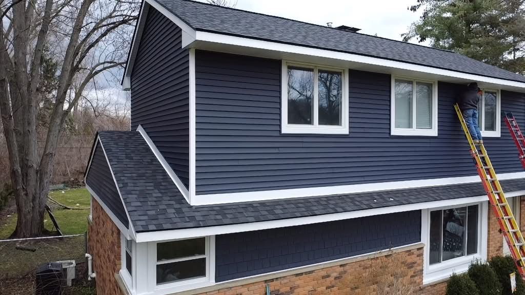 A blue house with a ladder on the side of it.