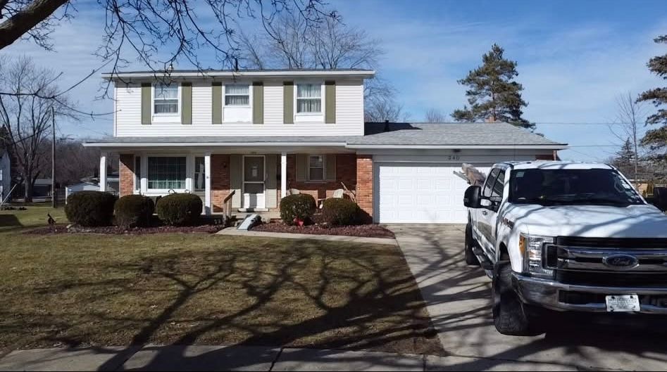 A white truck is parked in front of a house. A white truck is parked in front of a house.