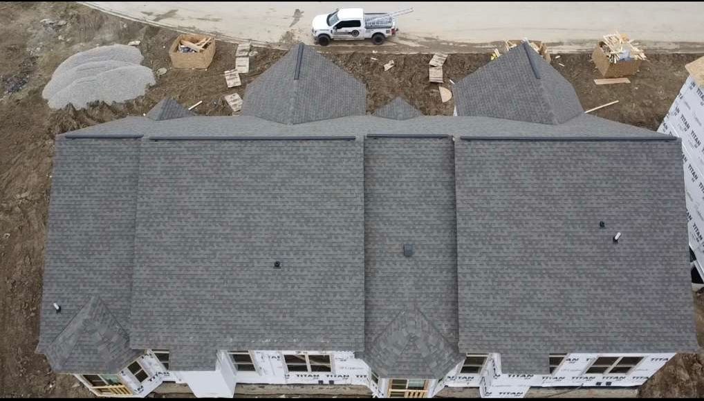 An aerial view of a house under construction with a truck parked in front of it.