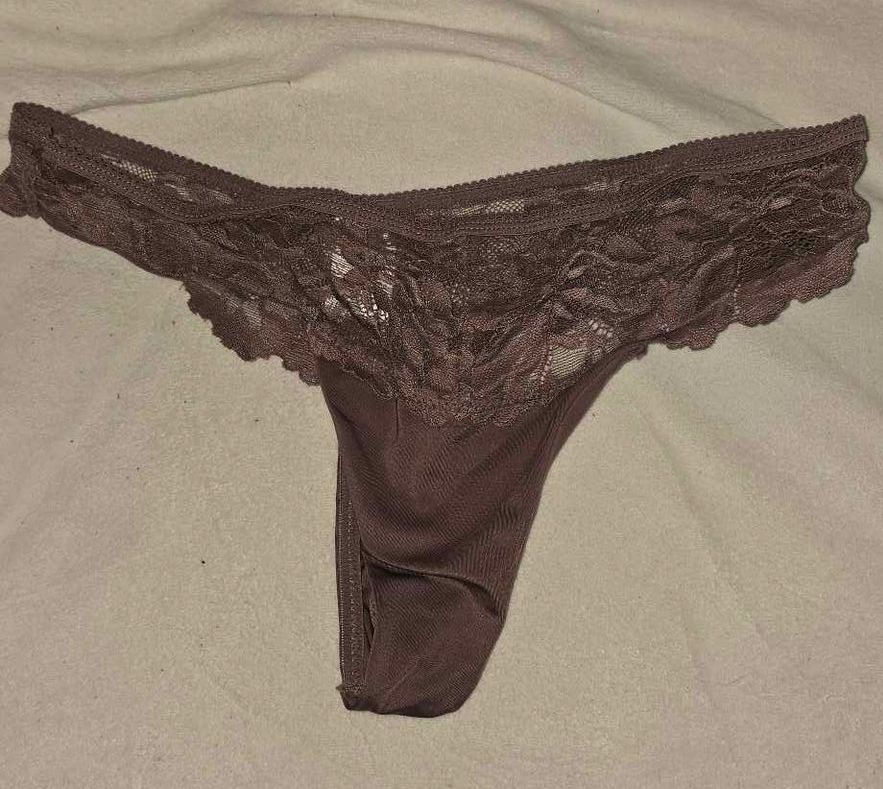 Een mauve kanten string op een witte stoffen ondergrond.
