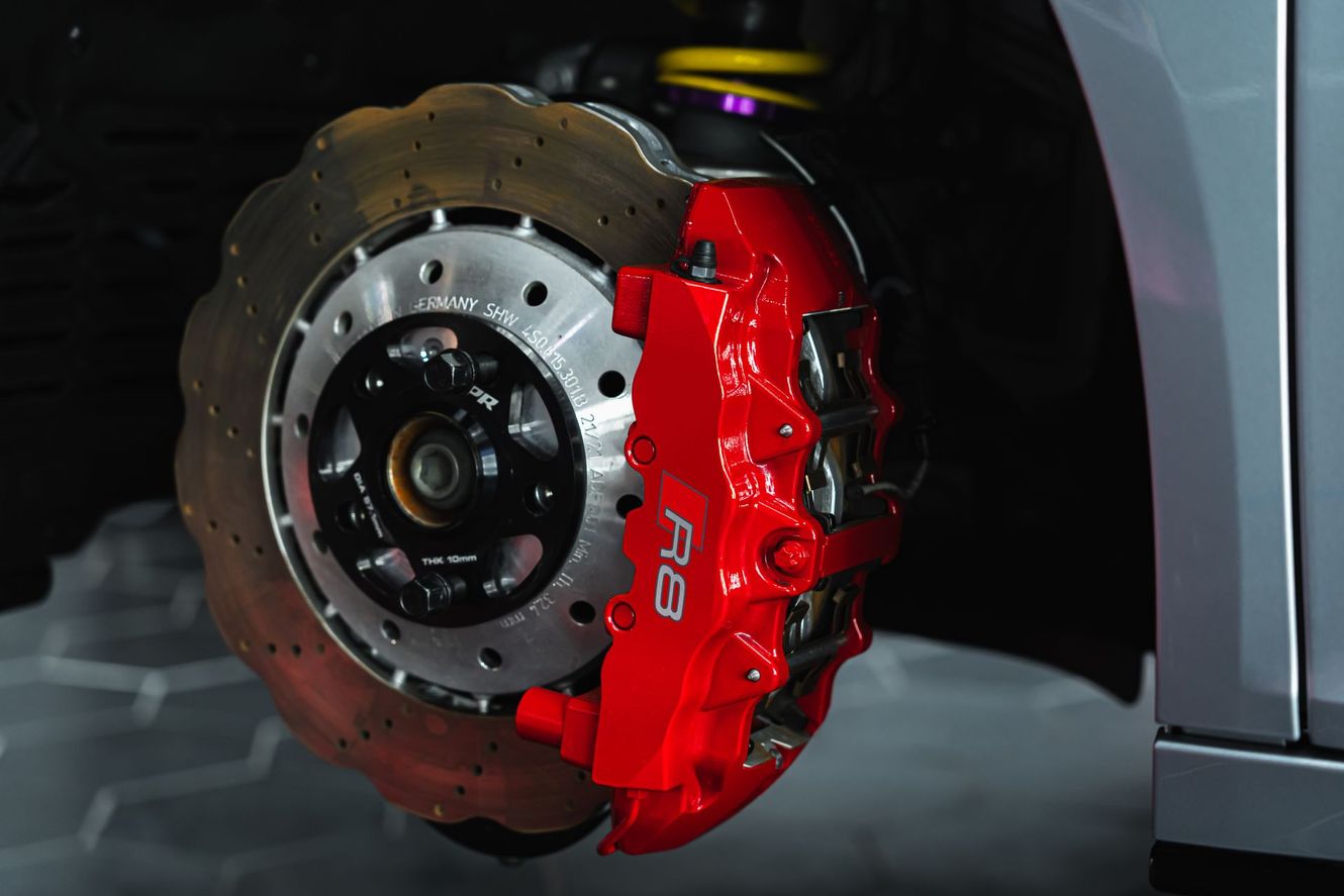 Red Audi R8 brake caliper and drilled rotor.