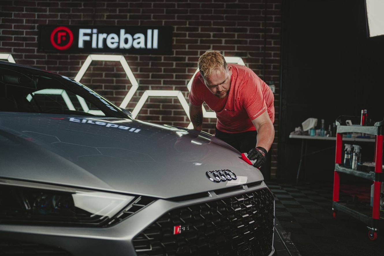 Man detailing a silver Audi under the 
