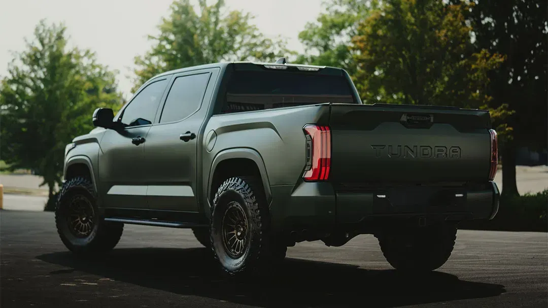 Dark green Toyota Tundra pickup truck parked on asphalt.