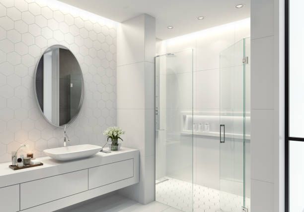 Luxurious white bathroom with hexagonal tiles, long sink, oval mirror, and glass doors.