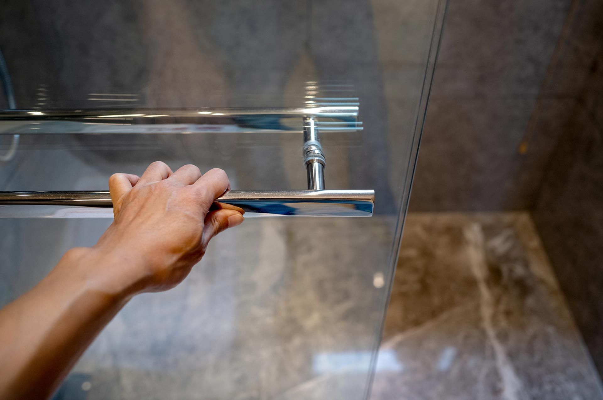 Hand pulling a bathroom sliding glass door. Hand pulling a bathroom sliding glass door.