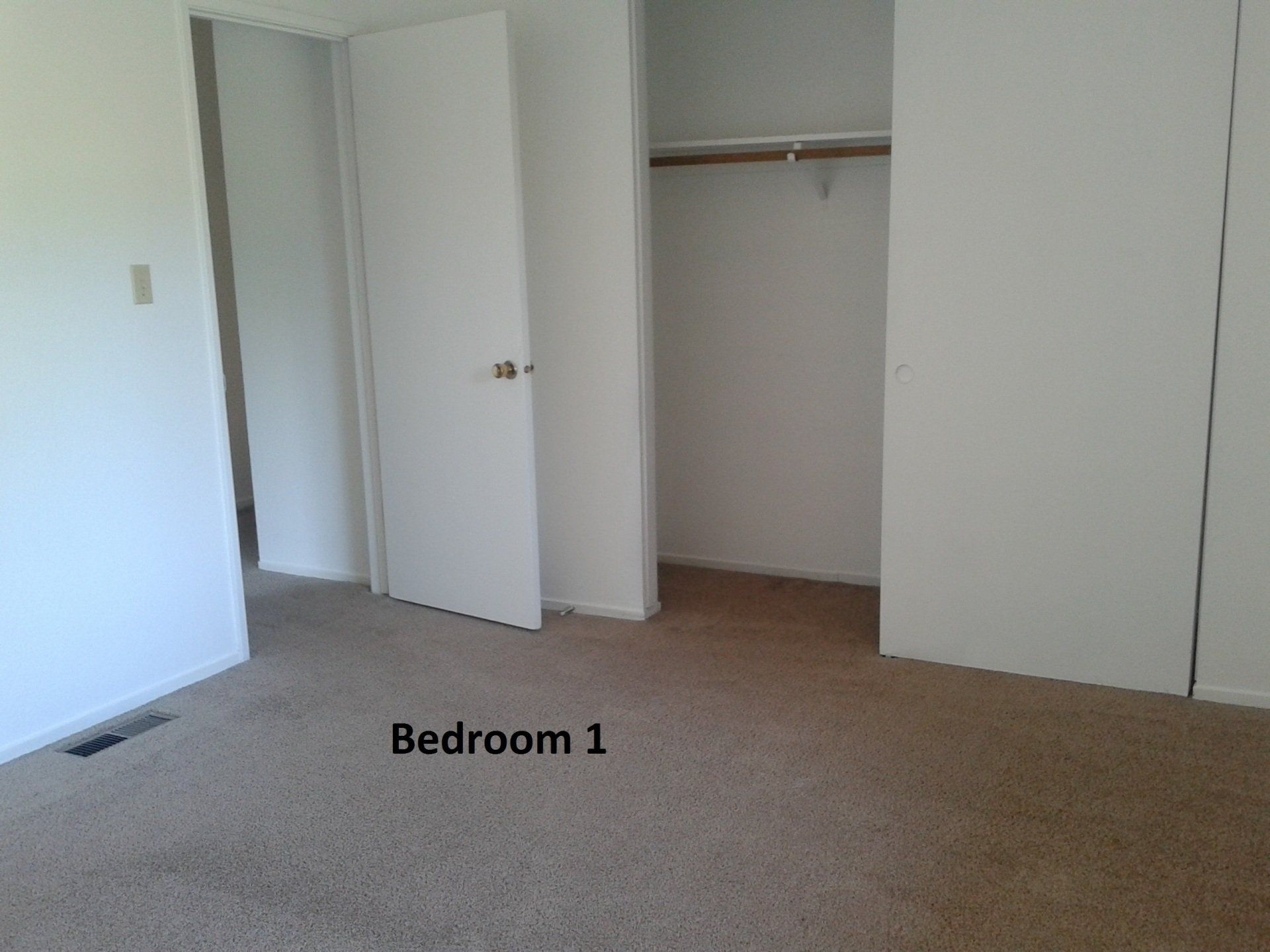 Bedroom 1 with beige carpet and closet