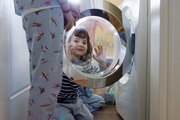 Little Girl Looking Through Washing Machine — San Pablo, CA — Alvarez Appliance Repair Little Girl Looking Through Washing Machine — San Pablo, CA — Alvarez Appliance Repair