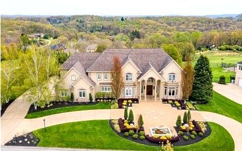 An aerial view of a large house with a large driveway