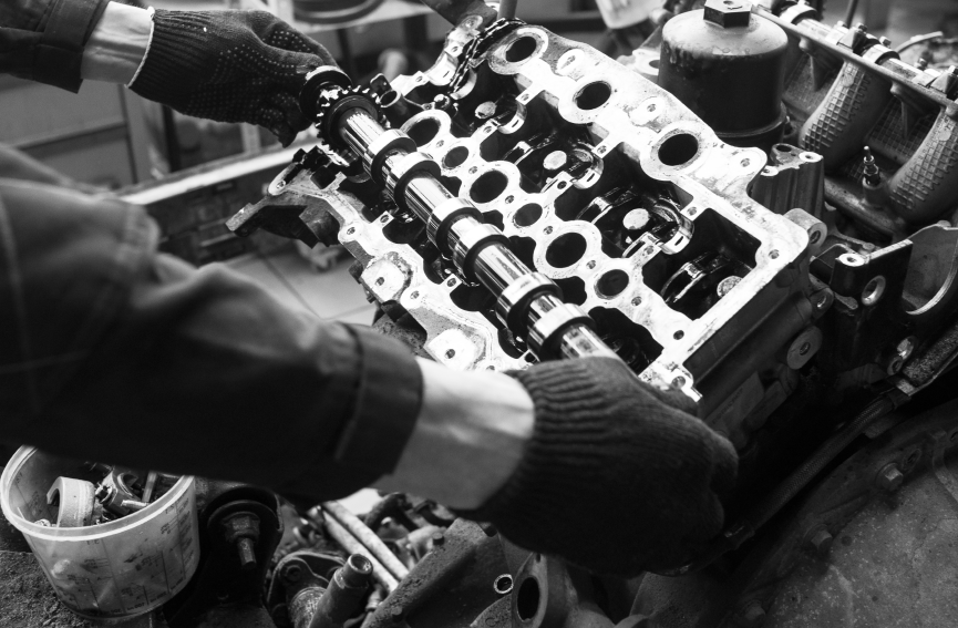 Hands in gloves assembling engine parts.