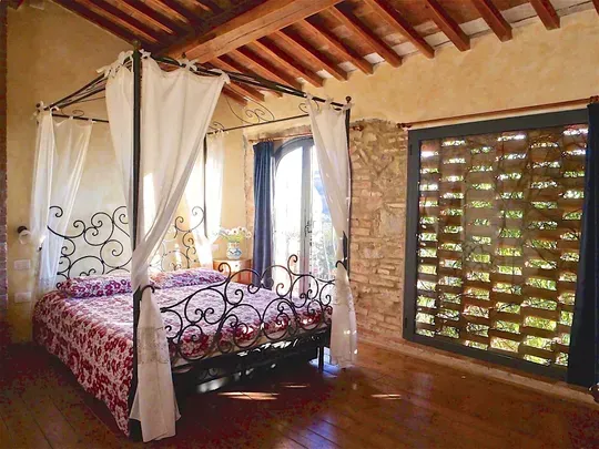 Camera con travi a vista e letto a baldacchino  in appartamento in Toscana