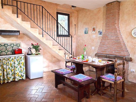 Soggiorno con angolo cottura e frigo in appartamento agriturismo in Toscana
