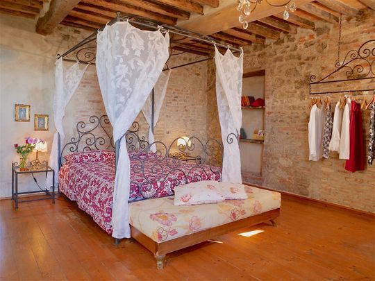Suite Grande di charme dell’Agriturismo I Pitti con pietra a vista e arredi tradizionali toscani