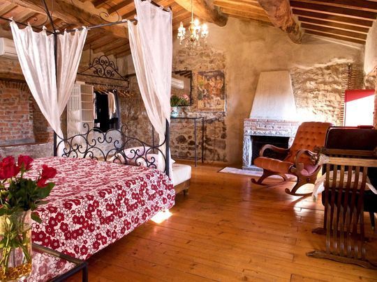 Camera matrimoniale con soffitto in legno e dettagli in stile toscano, in agriturismo di charme vicino Pistoia