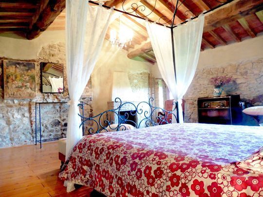 Letto a baldacchino in ferro battuto e interni in pietra a vista dell’Agriturismo I Pitti in Toscana
