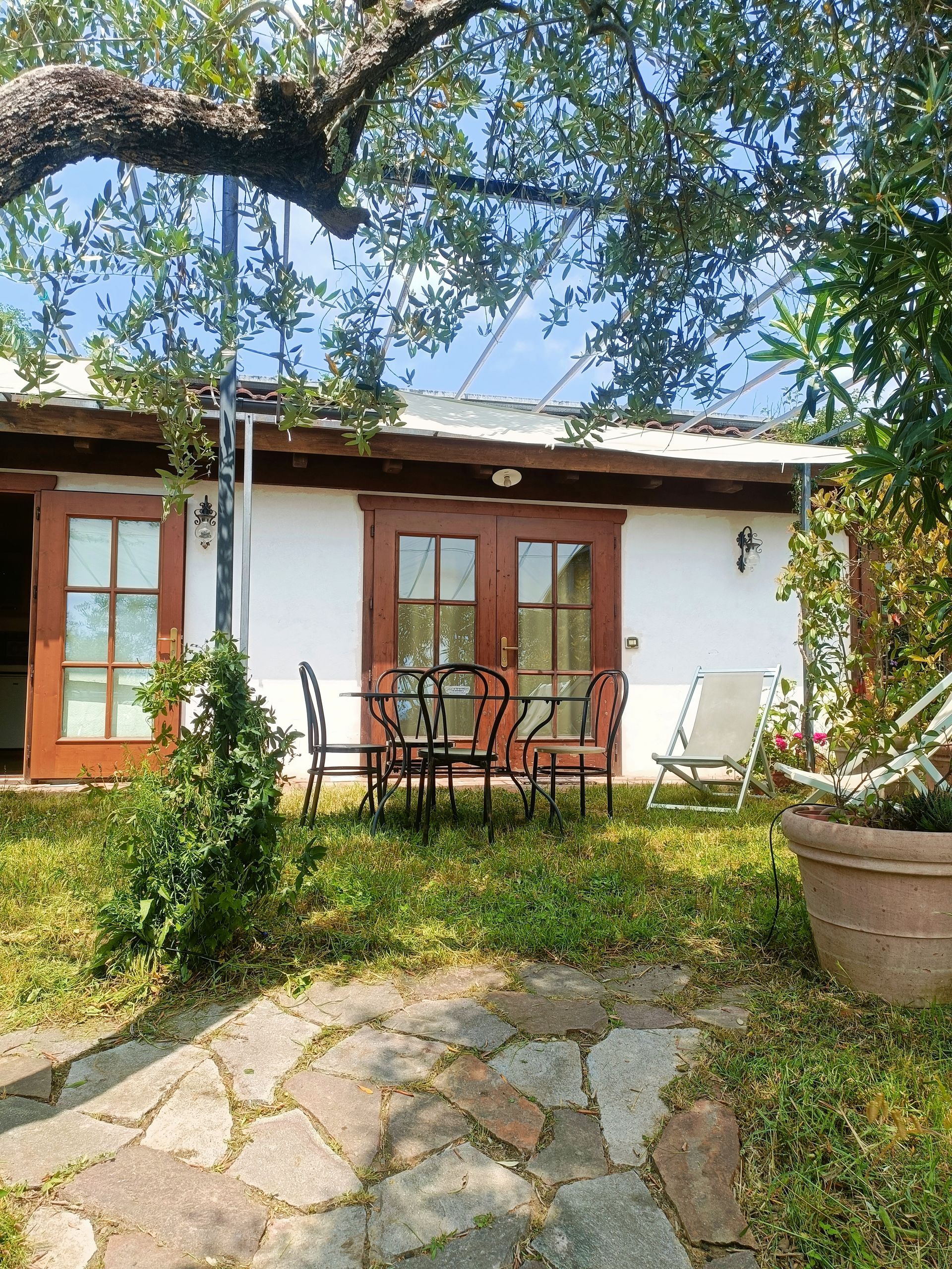 Giardino e zona pranzo e teli ombreggianti dell'appartamento dell’Agriturismo I Pitti in Toscana vicino Pistoia