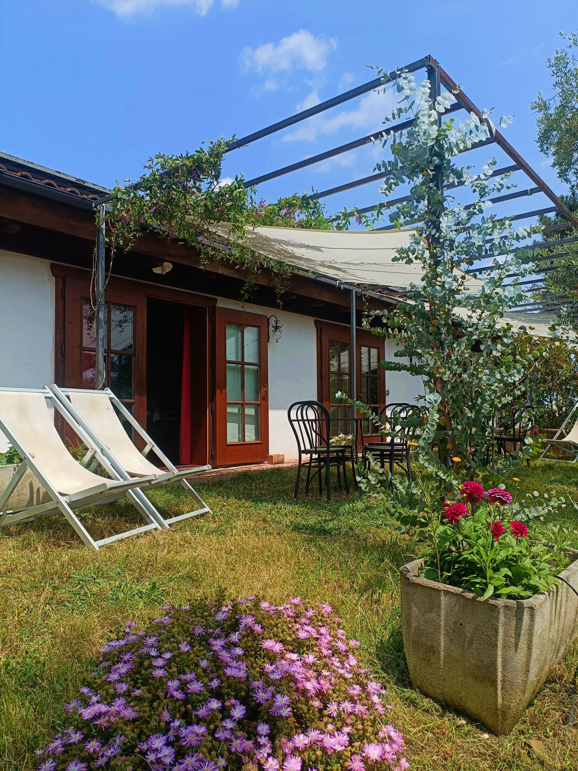 Giardino e zona pranzo e teli ombreggianti dell'appartamento dell’Agriturismo I Pitti in Toscana vicino Pistoia